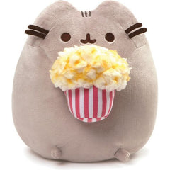 GUND is proud to present Pusheen — a Chubby Gray tabby cat that loves cuddles, snacks, and dress-up. As a popular web comic, Pusheen brings brightness and chuckles to millions of followers in her rapidly growing online fan base. This 9.5” upright plush version of Pusheen has her ready to enjoy a movie with an overflowing bucket of yummy Buttered popcorn! Surface-washable for easy cleaning. Appropriate for ages one and up. About GUND: for more than 100 years, GUND has been a premier plush Company recognized